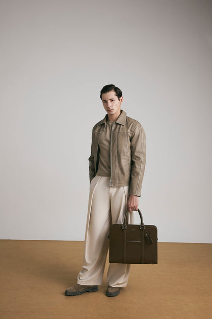 Luxury lifestyle shot of PinnaclePro dark brown branded leather laptop bag for men, complementing a sophisticated and professional look.